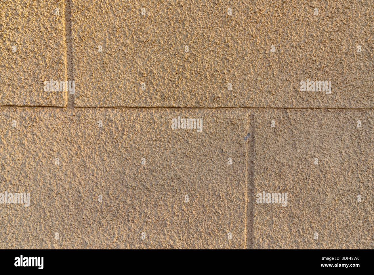 Beige stone wall texture with rectangular blocks and rough architectural surface Stock Photo