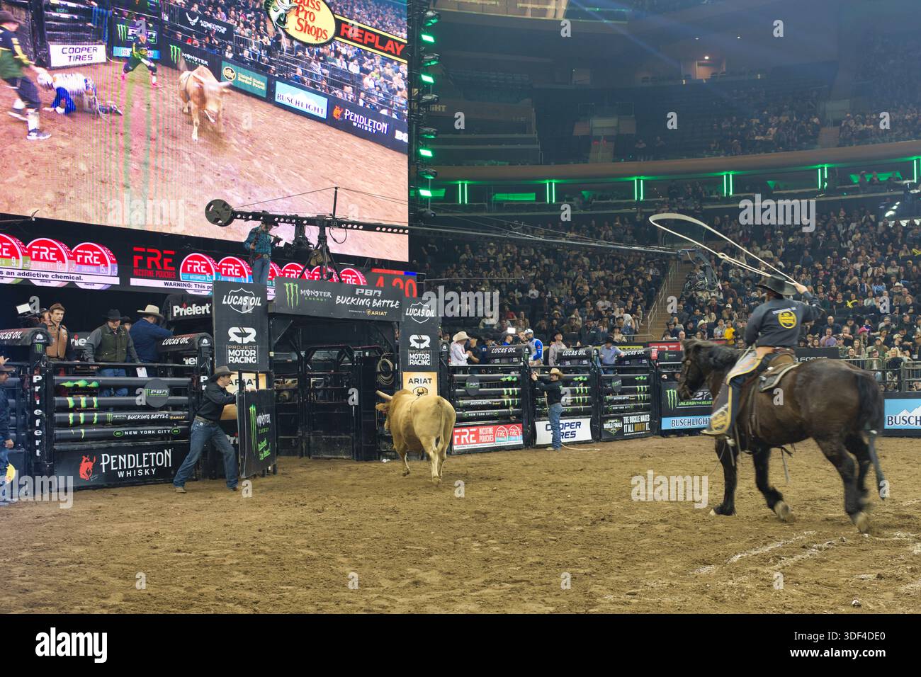 Watching Rodeo A rodeo event featuring cowboys and bulls in an arena, with a large ...