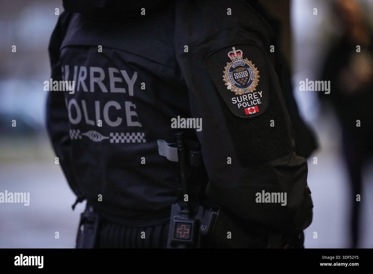 A Surrey police department logo is seen on an officer's jacket in ...
