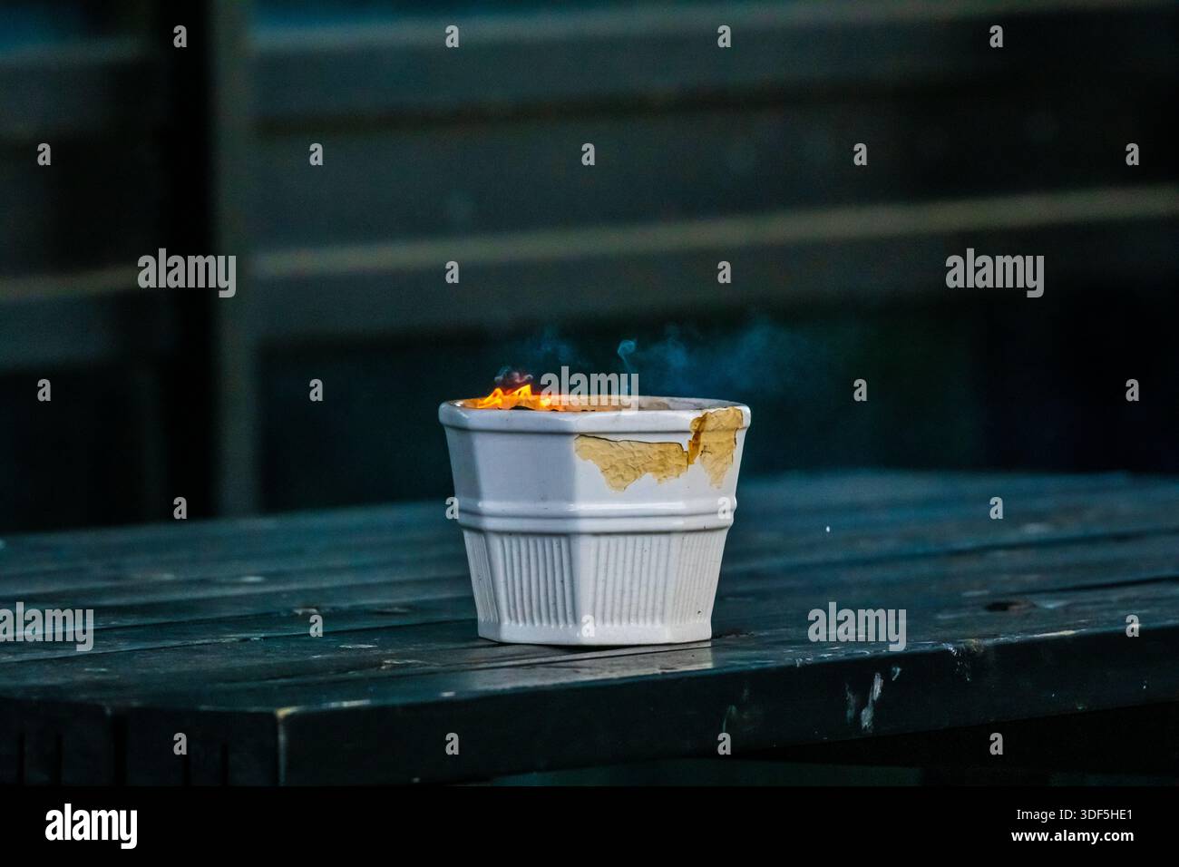 Fire rising from an ashtray on a table Stock Photo