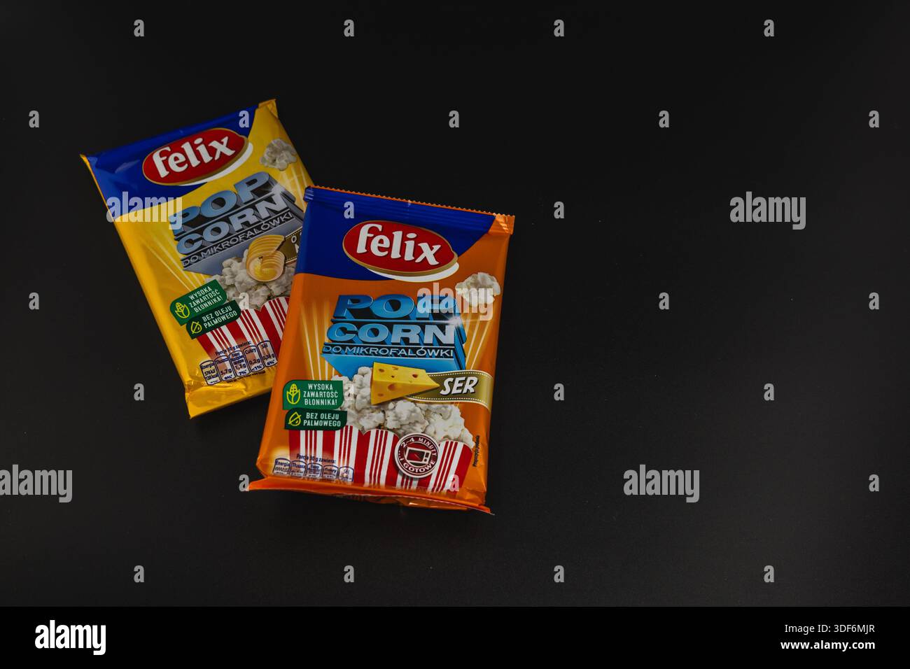 Lviv Ukraine 12.08.2025 Two bags contain popcorn with distinct flavors. They are placed on a dark surface. The snack packaging displays labels and ima Stock Photo