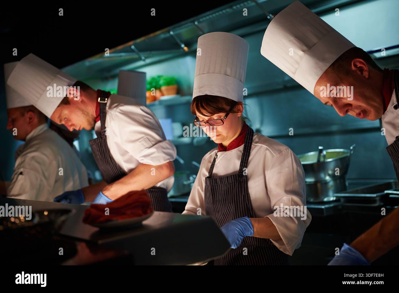 Chefs working together in professional restaurant kitchen Stock Photo