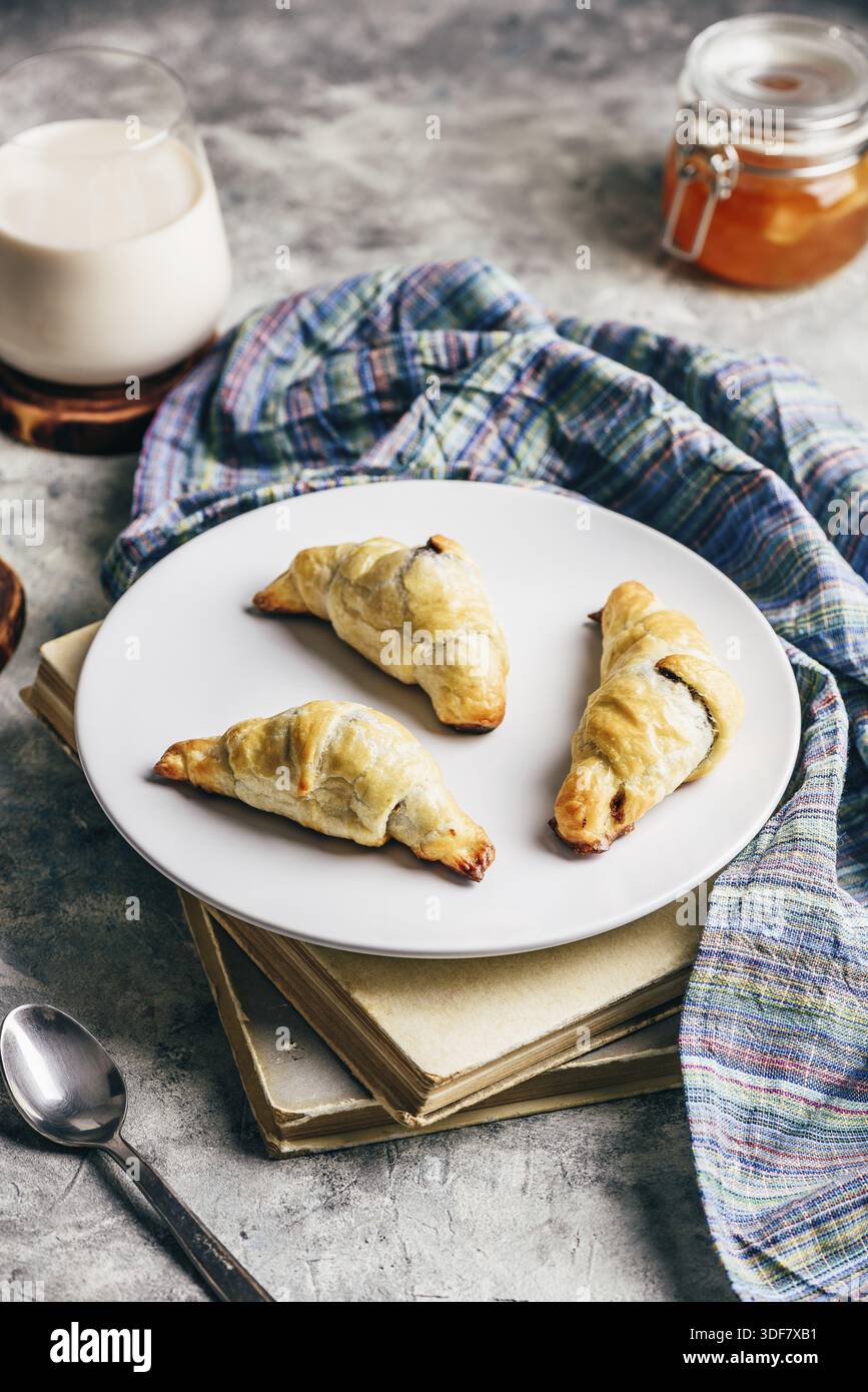 Fresh baked croissants stuffed with nuts and chocolate spread for breakfast Stock Photo
