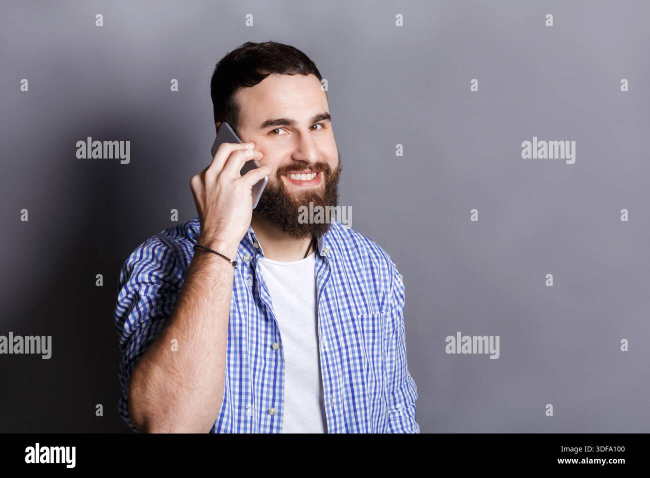 Cheerful bearded man talking on phone Stock Photo