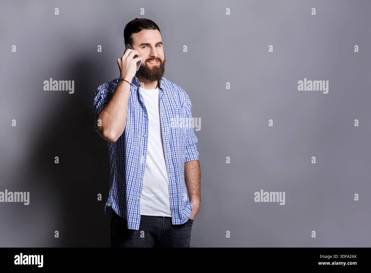 Cheerful bearded man talking on phone Stock Photo