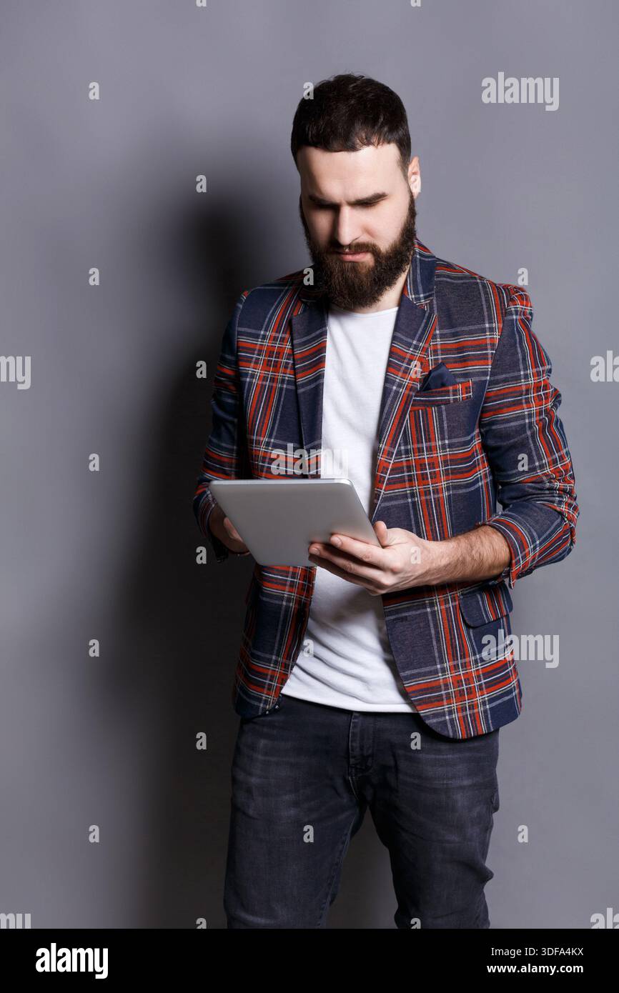 Young bearded man using tablet computer Stock Photo