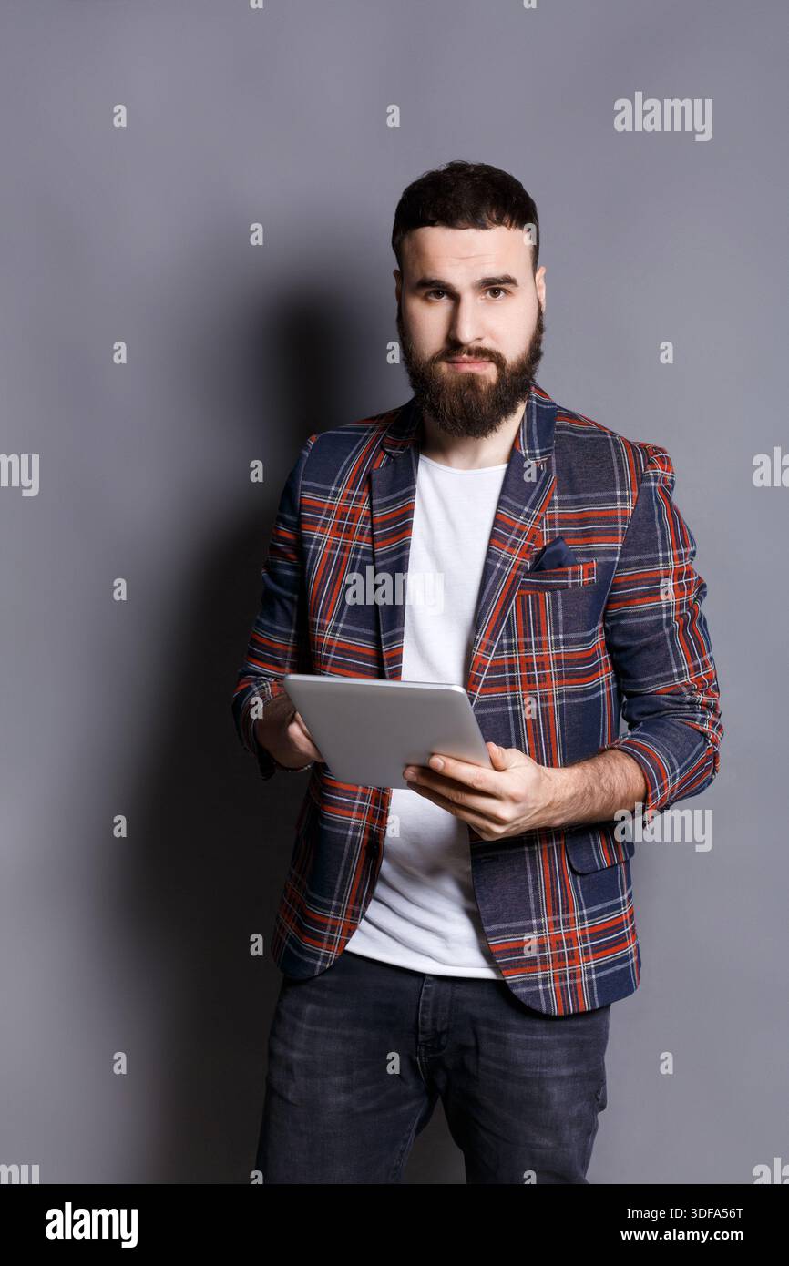 Young bearded man using tablet computer Stock Photo