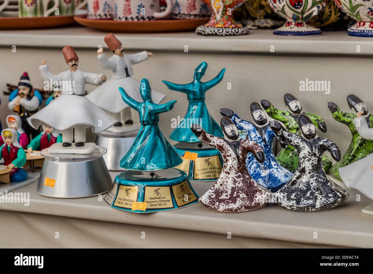 Spinning dervish figurines in ceramic and porcelain stand for sale in a souvenir shop in Sille near Konya, Turkey, alongside musician figurines and traditional Turkish tableware. The figurines allude to the Sema ceremony of the whirling dervishes practised by followers of the Sufi mystic Rumi in Konya. Stock Photo