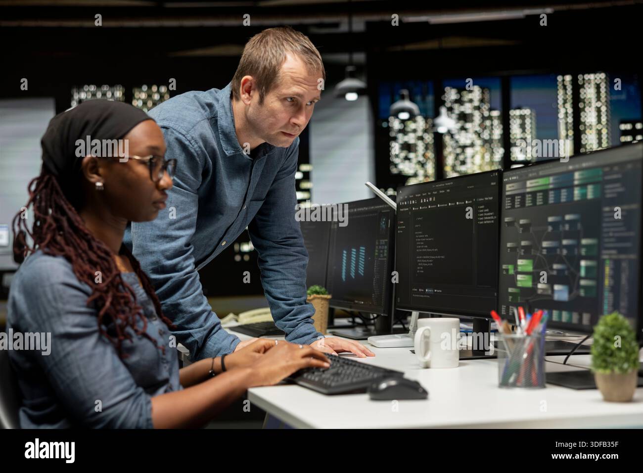 Manager discussing with tech startup admin coding AI algorithms on PC. System administrator having conversation with IT professional in office using deep learning models to do automation Stock Photo