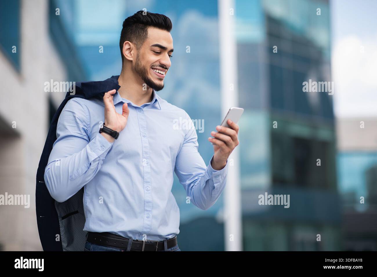 Middle-eastern young entrepreneur checking emails on smartphone Stock Photo