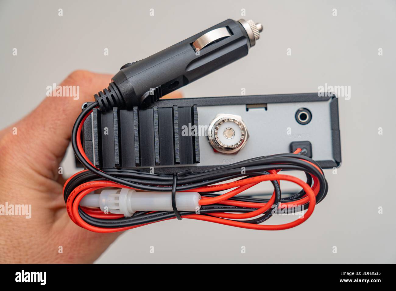 car radio that plugs into cigarette lighter CB car radio, 27MHz citizen band, 40 channels, RETEVIS brand, with PTT,  female connector and 12-volt cigarette lighter plug. Black, rectangular  shape Stock Photo