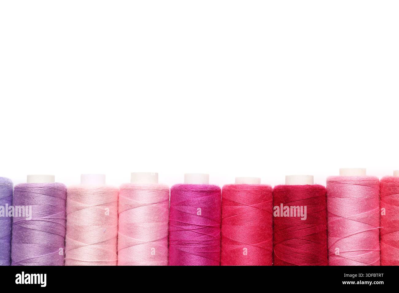 Different spools of thread on white background Stock Photo