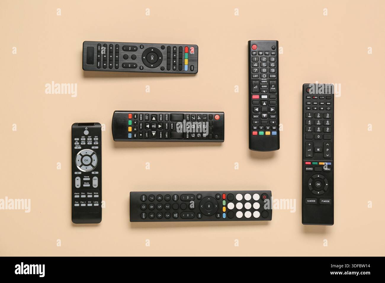 Different modern TV remote controls on beige background Stock Photo