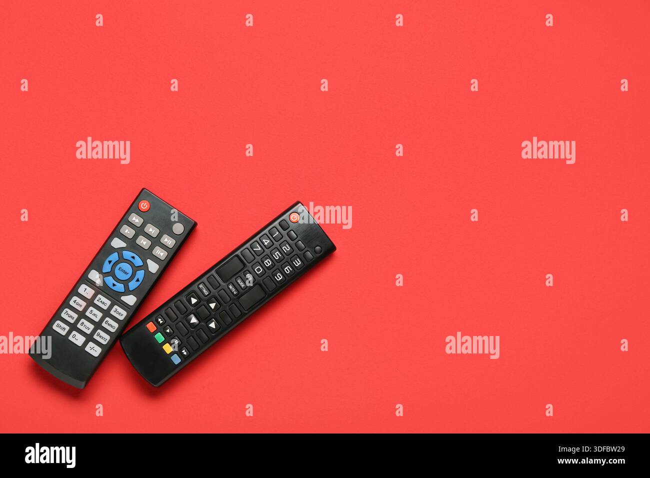 Different modern TV remote controls on red background Stock Photo