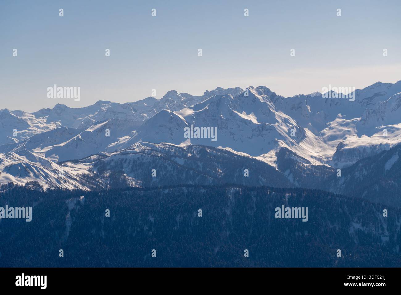 Panoramic view of a snow-capped mountain range under a clear blue sky ...