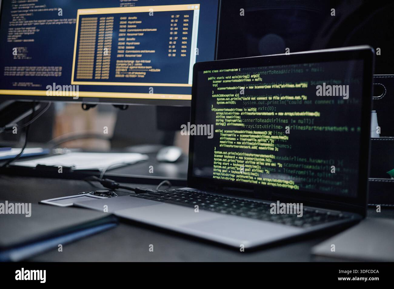 Closeup of Laptop Displaying Programming Code on Desk in Modern Office Stock Photo