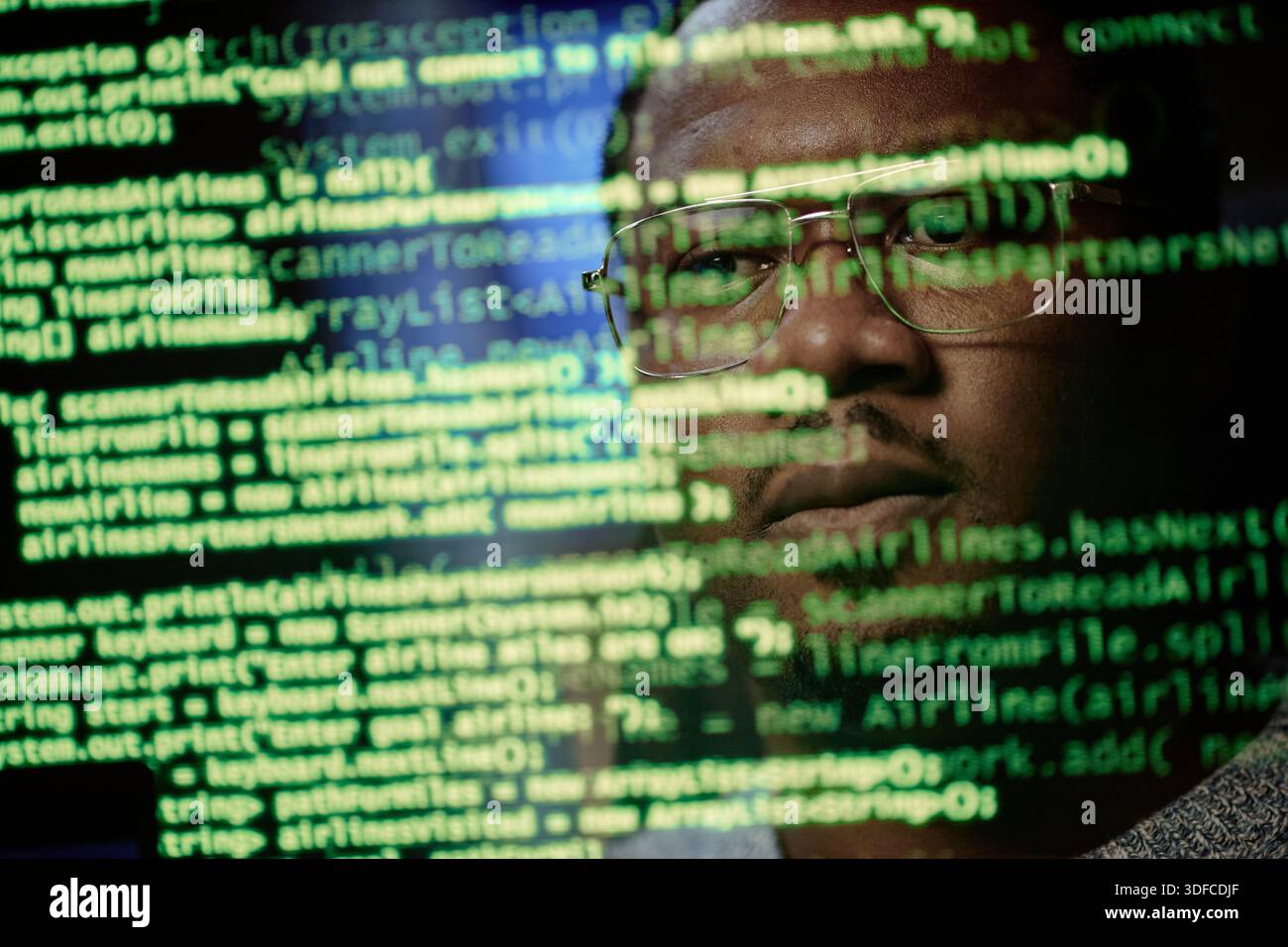 Portrait of Young Adult Black Man Analyzing Code Reflected on Computer Screen Stock Photo