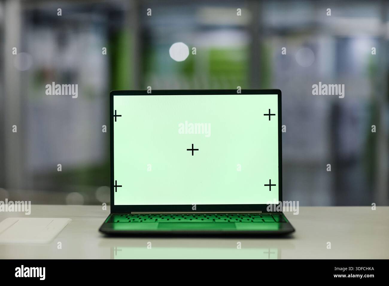 Modern Laptop Computer Displaying Blank Green Screen with Calibration Marks Stock Photo