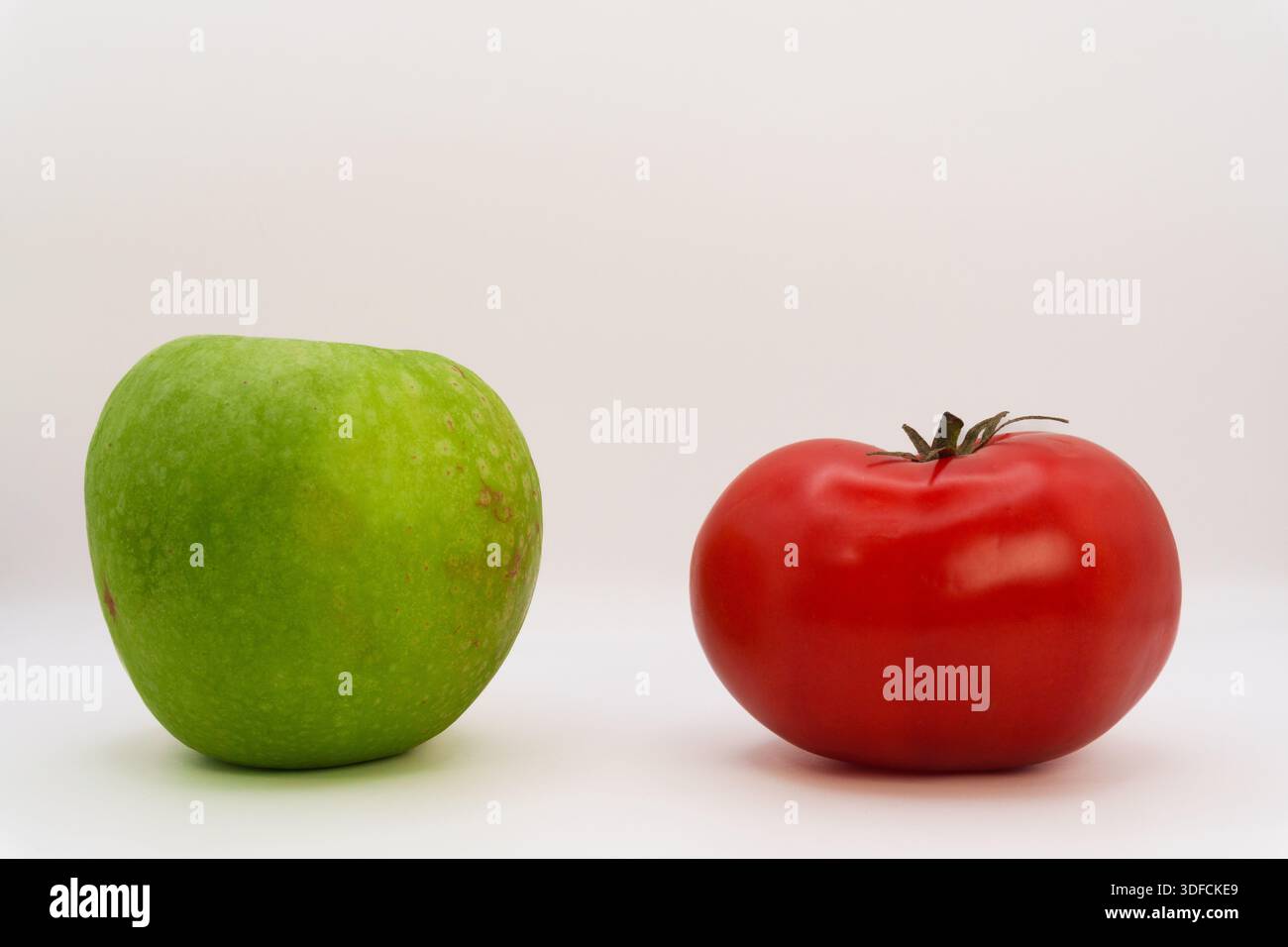 Apple vs tomato on white background, vegetables vs fruits, healthy ...