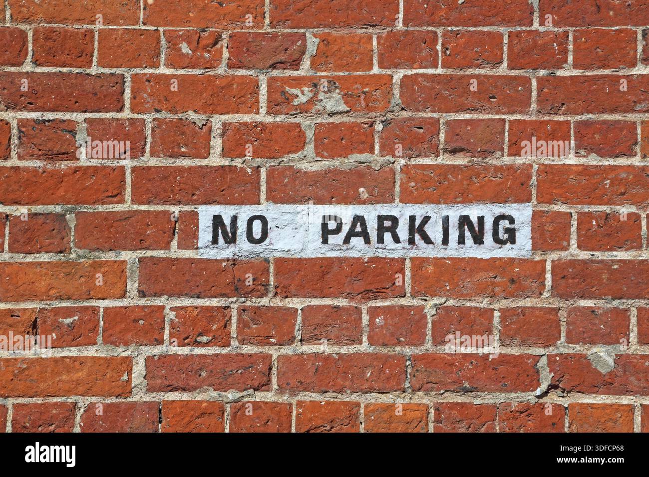 no parking sign painted on a brick wall Stock Photo - Alamy