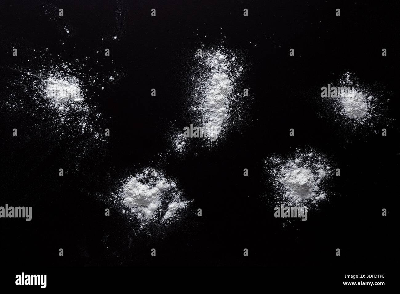 Sprinkled wheat flour splash spots on black background Stock Photo