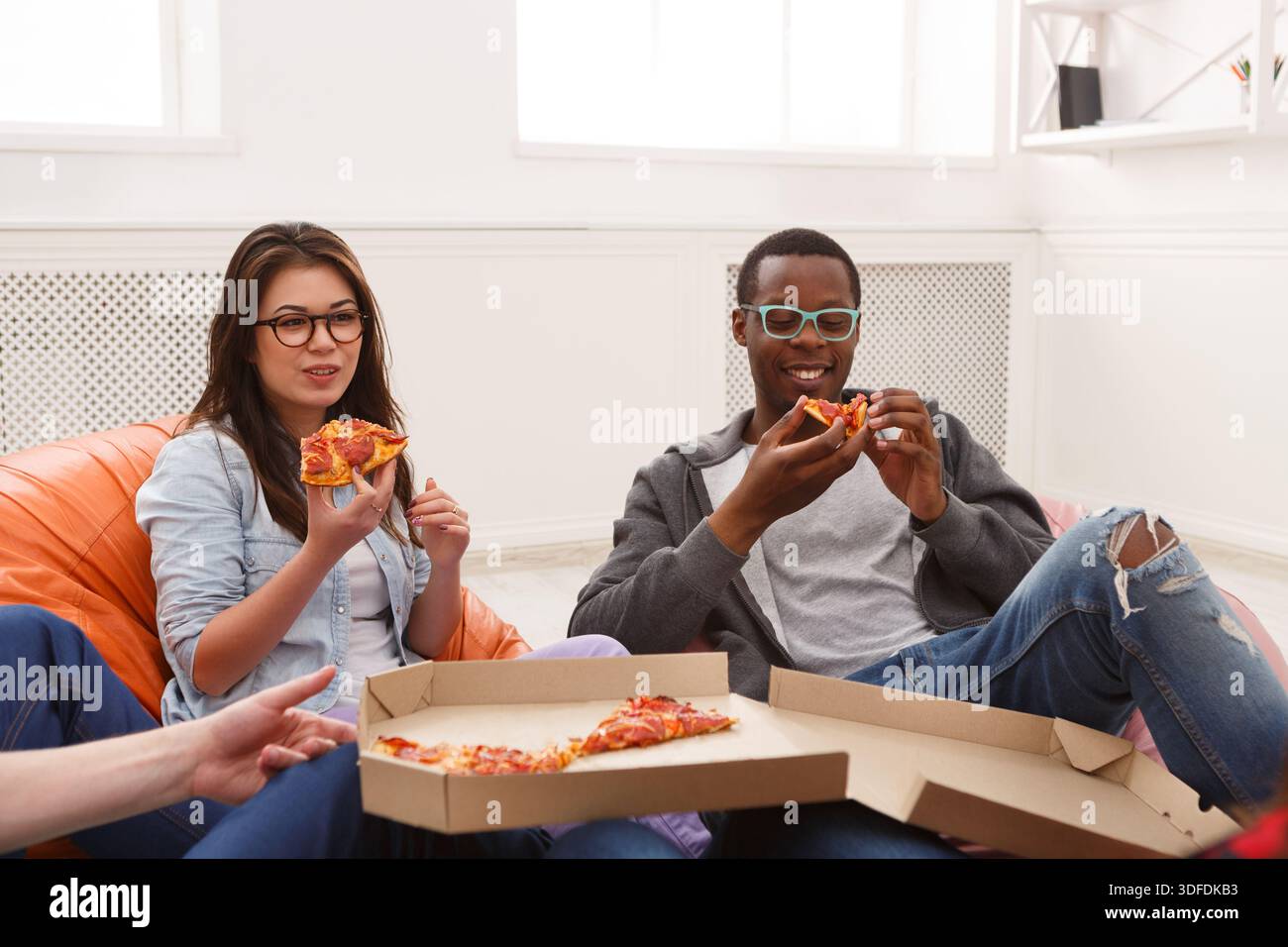Students sharing pizza at home party Stock Photo