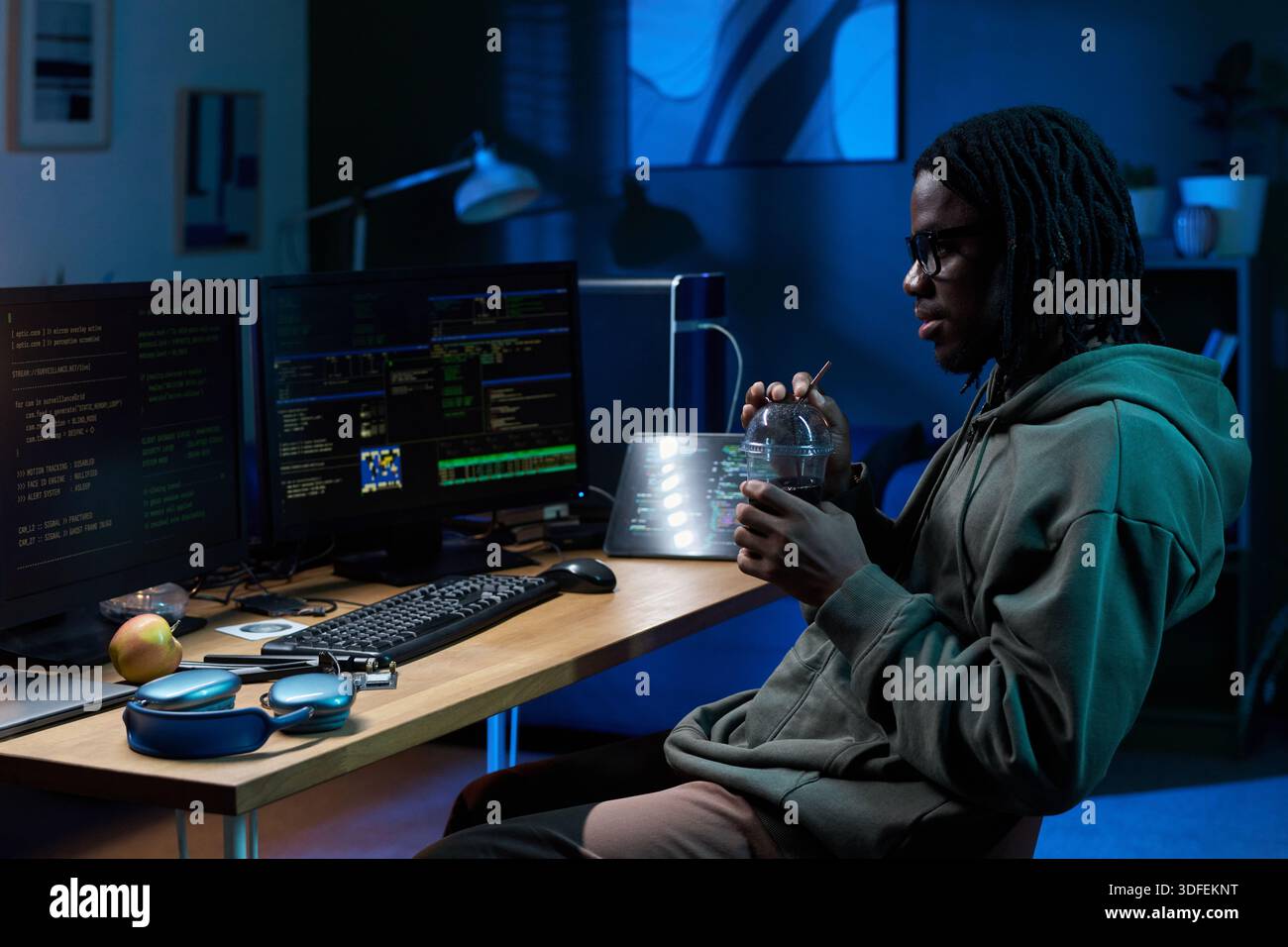 Young Black Man Working on Computer at Night in Office Setting Stock Photo
