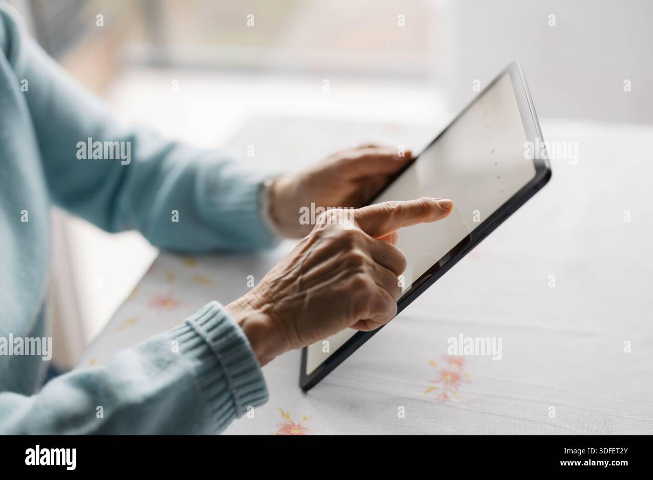 Senior woman using digital tablet at home Stock Photo