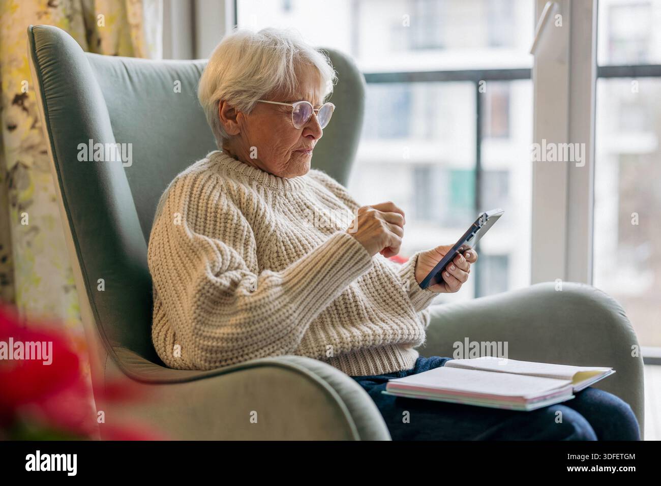 Senior woman using written notes and mobile phone Stock Photo