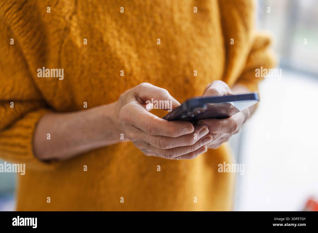 Senior woman using smart phone at home Stock Photo