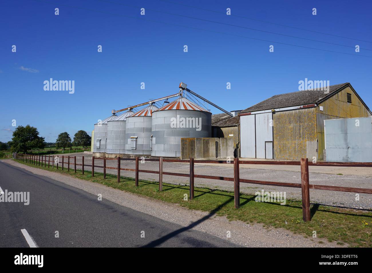 Agricultural grain bins on farm. farmyard storage buildings and ...