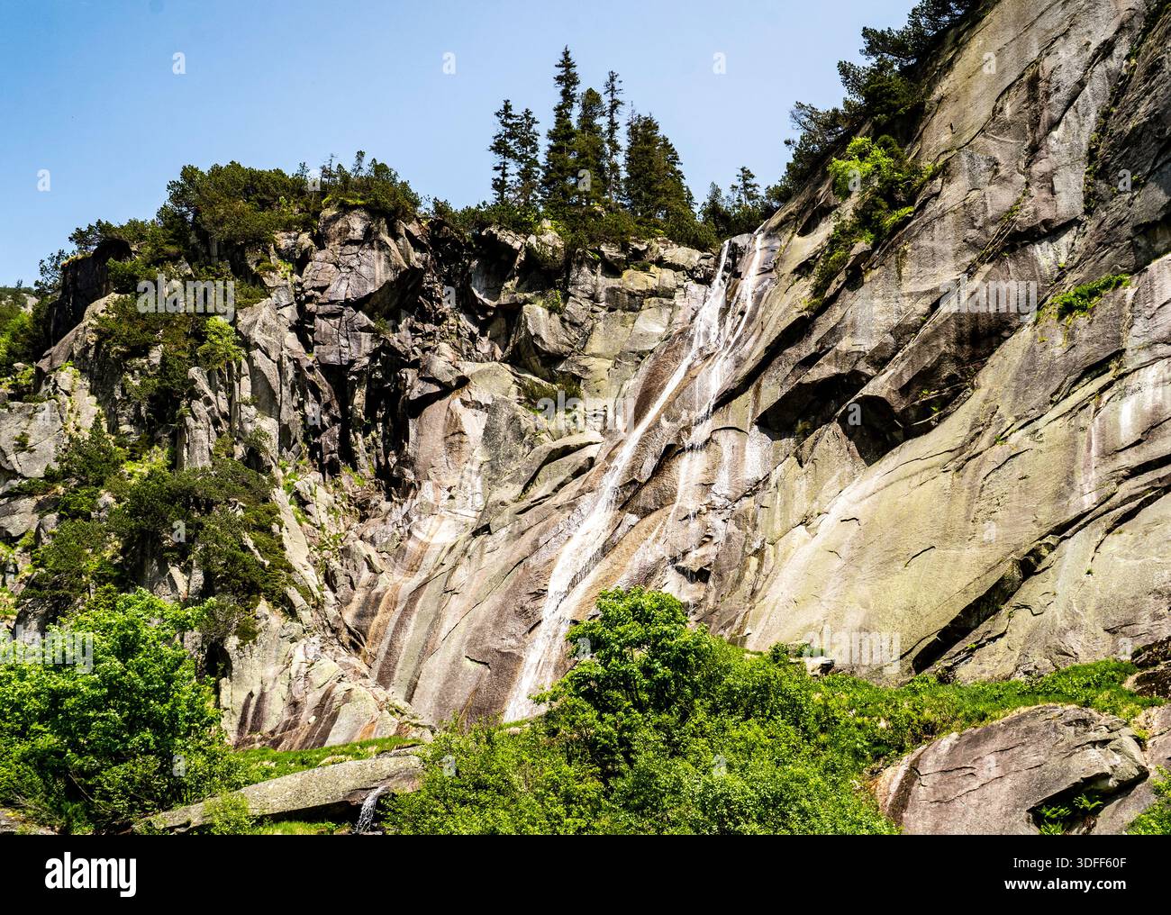 A scenic waterfall cascading down a rocky cliff surrounded by lush ...
