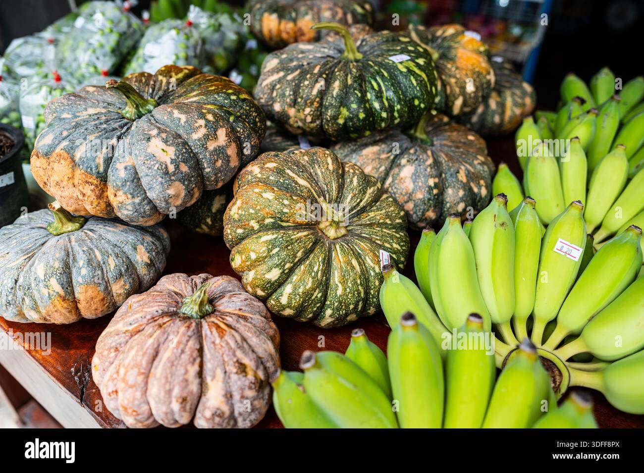 Big pumpkins and green bananas with price tag on table for sale Stock Photo  - Alamy