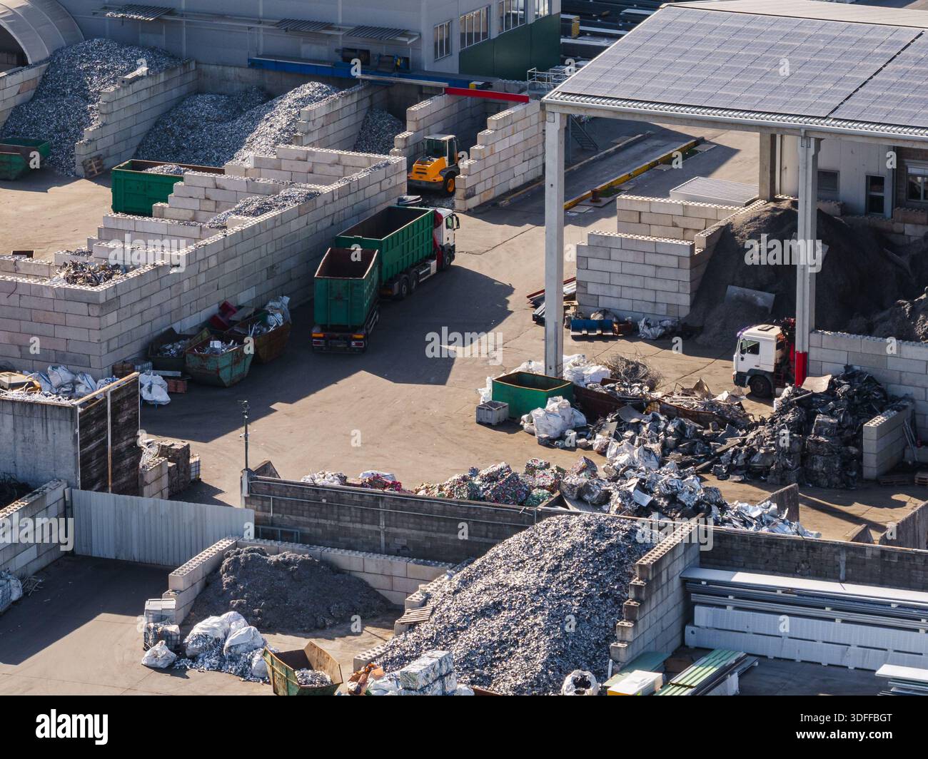 Aerial view shows a scrap metal recycling facility with trucks and ...