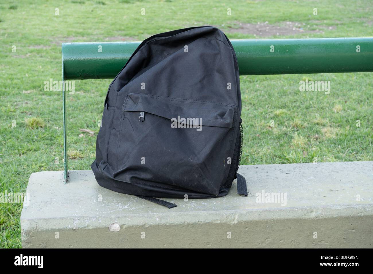 Black backpack. Isolated on a bench. Stock Photo