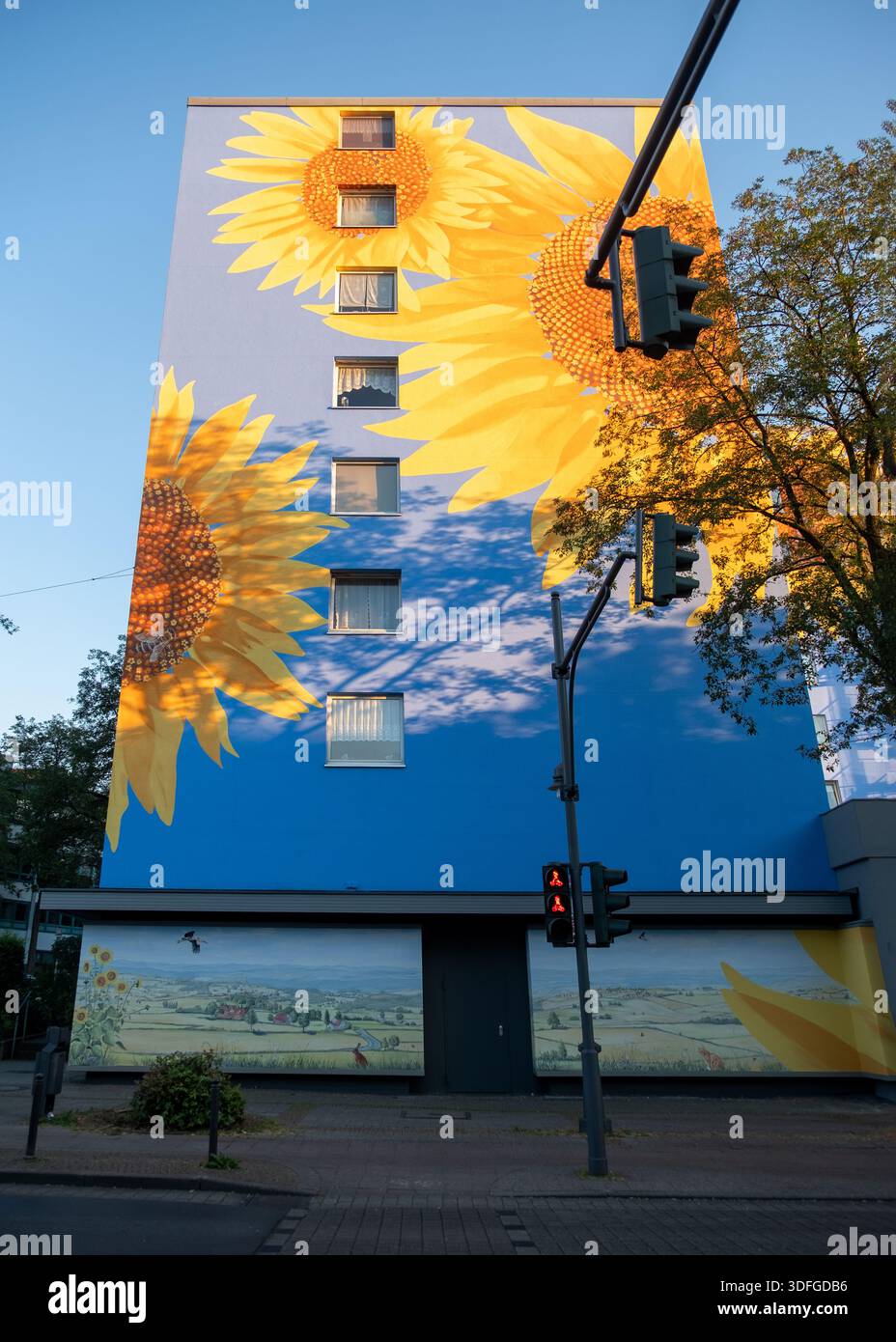 Bright, oversized sunflower mural spans a high-rise building facade in ...