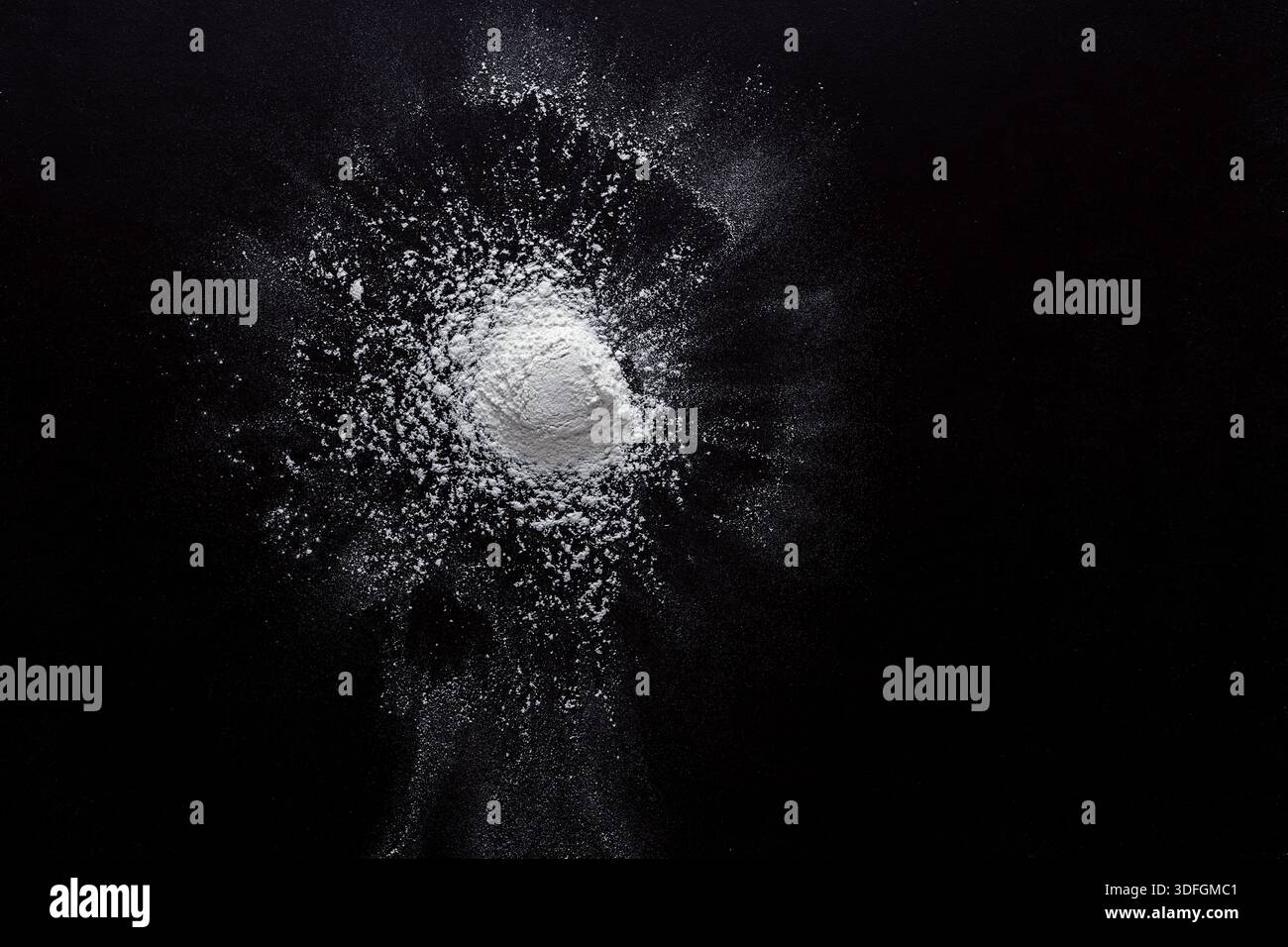 Sprinkled wheat flour splash spots on black background Stock Photo