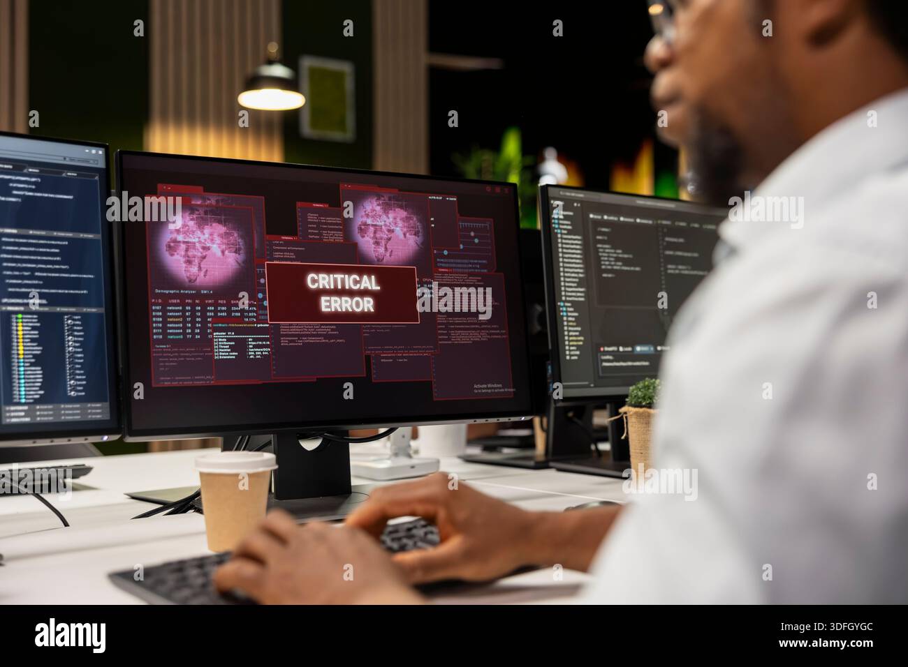 Close up of IT specialist at office desk thinking how to fix critical error alert displayed on PC screen. System administrator brainstorming how to fix computer bug affecting server network Stock Photo