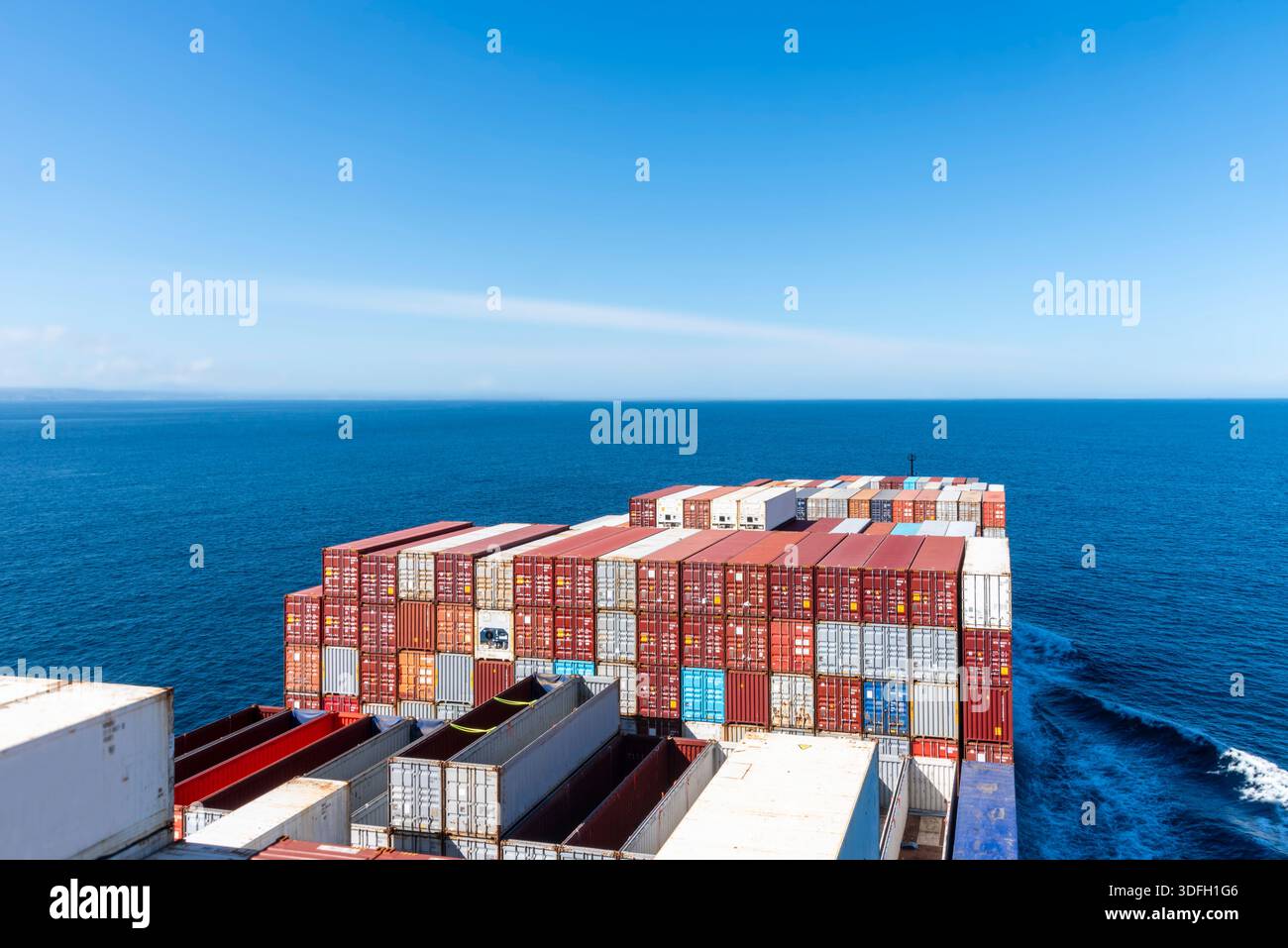 Angled view from ship bridge of container vessel sailing across calm ...