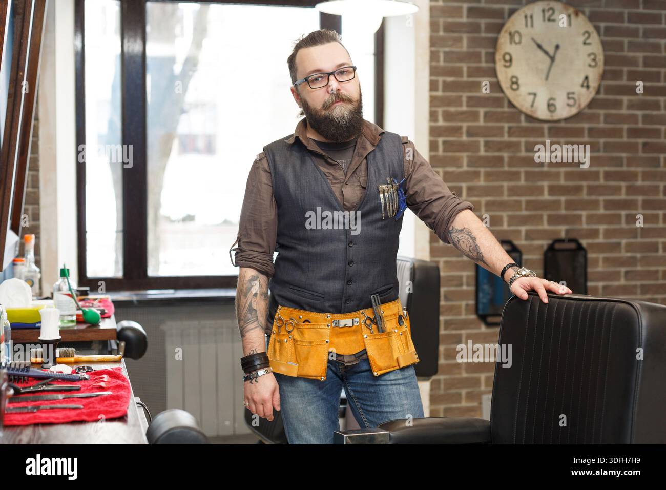 Bearded barber posing to camera at barbershop Stock Photo