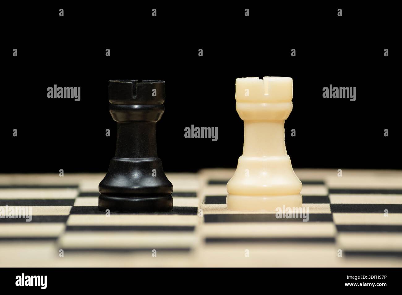 Macro photo to a pair of white and black rooks chess pieces over a ...