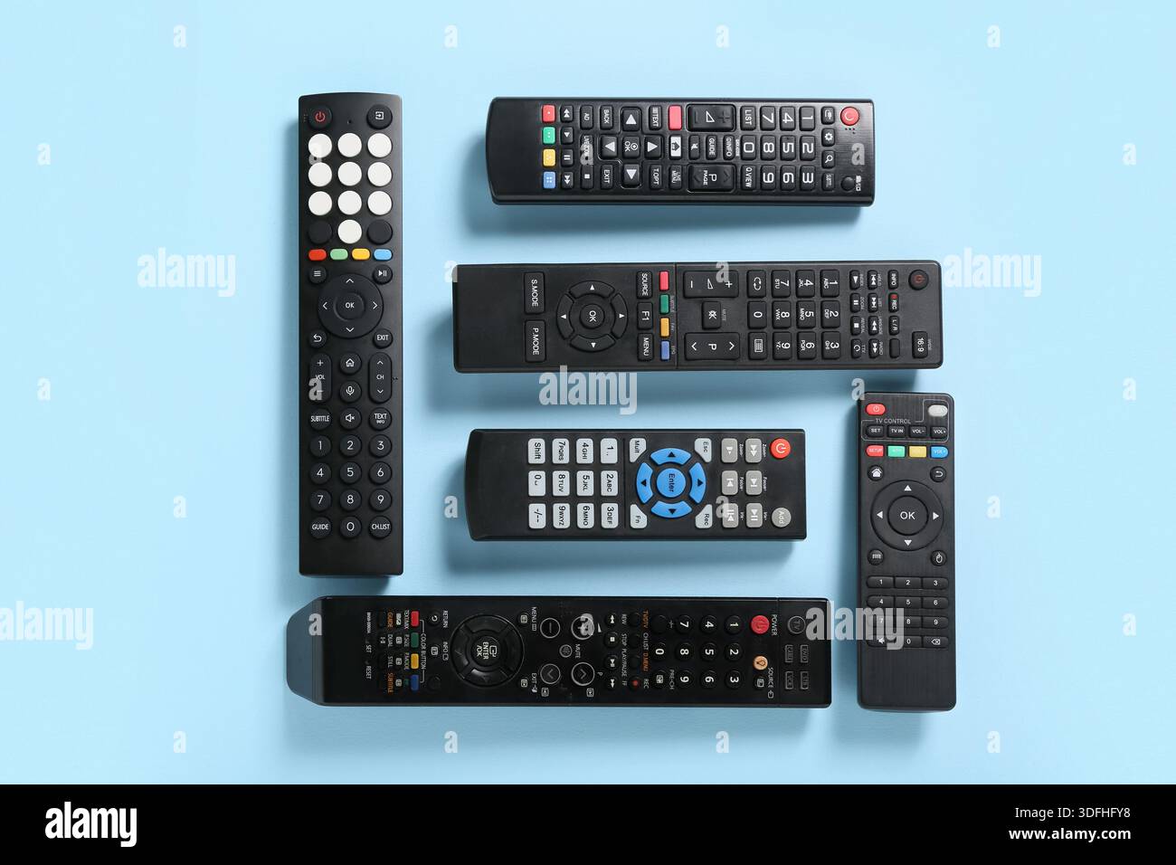 Different modern TV remote controls on blue background Stock Photo