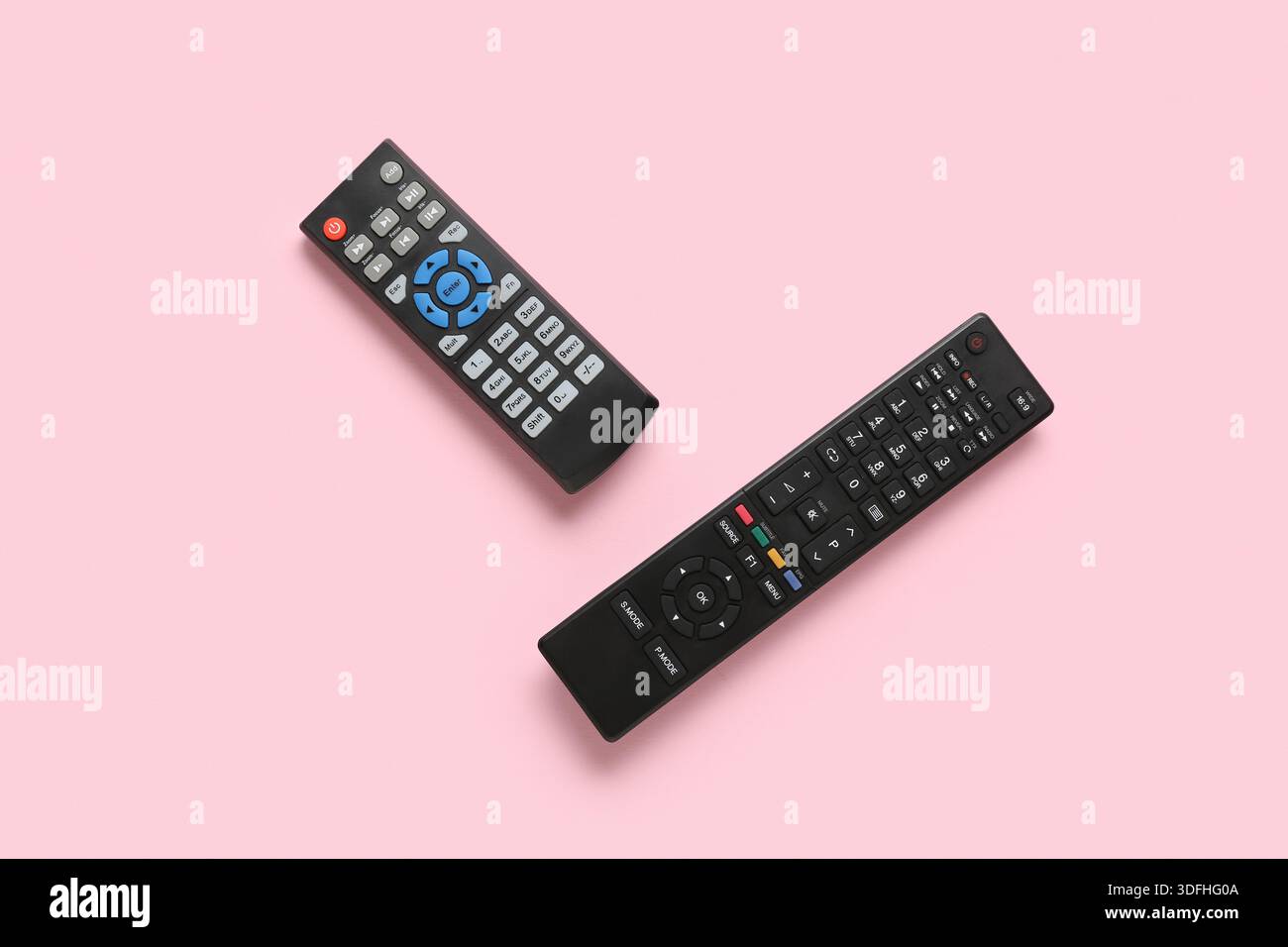 Different modern TV remote controls on pink background Stock Photo