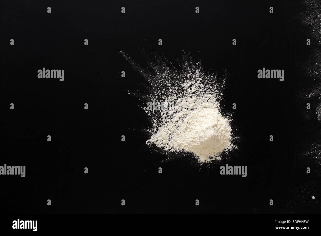 Sprinkled wheat flour splash spots on black background Stock Photo
