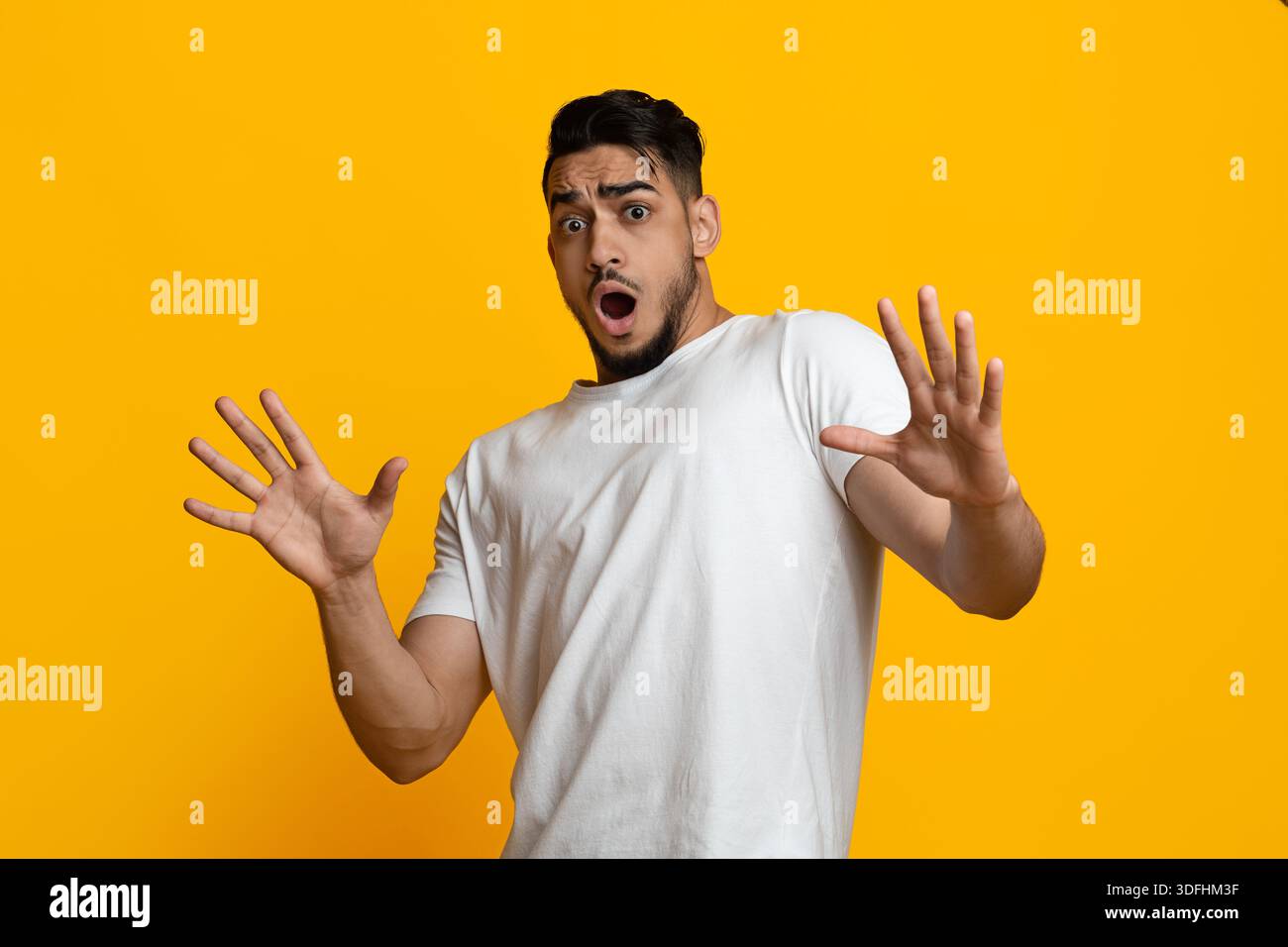 Scared arab guy in casual showing stop gesture Stock Photo