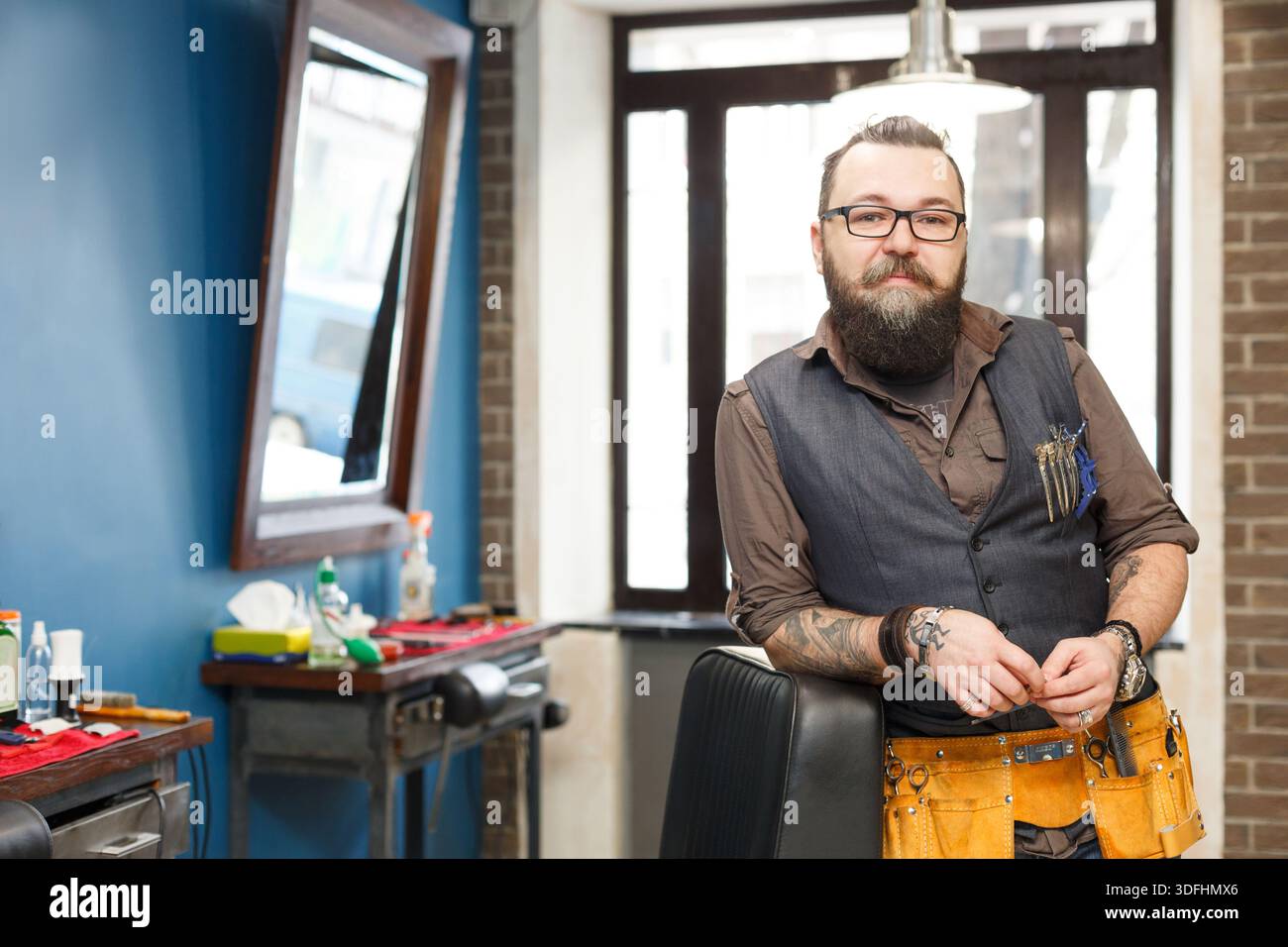 Bearded barber posing to camera at barbershop Stock Photo