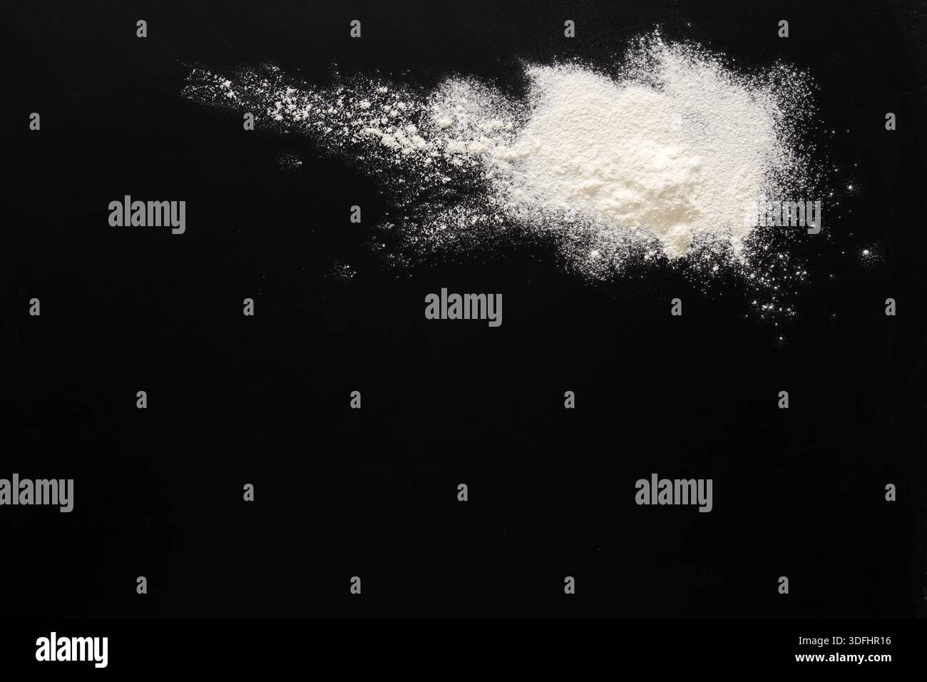 Sprinkled wheat flour splash spots on black background Stock Photo