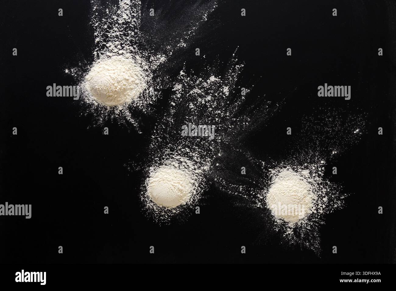 Sprinkled wheat flour splash spots on black background Stock Photo