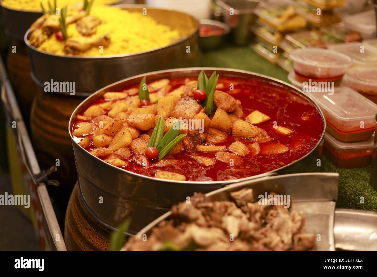 Traditional Thai Massaman curry chicken with potato in big pot at street food market stall offering authentic taste and delicious spicy flavor of loca Stock Photo