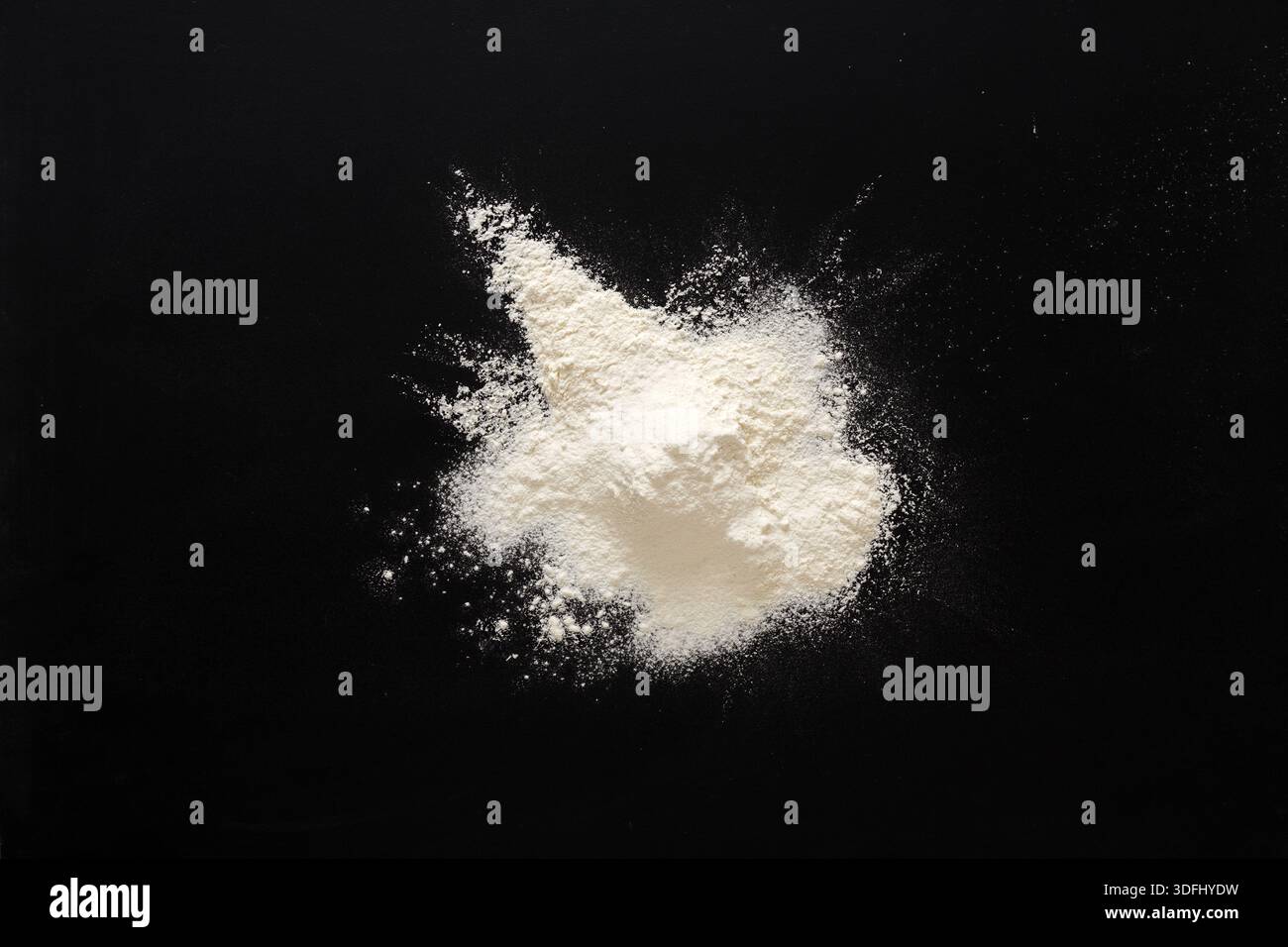 Sprinkled wheat flour splash spots on black background Stock Photo